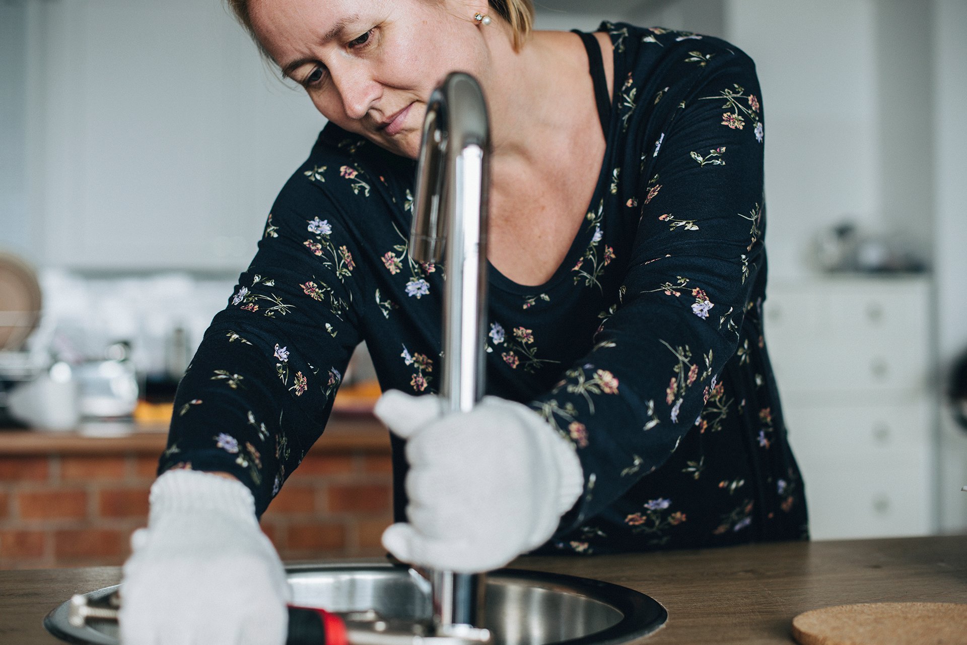 Handy woman fixing the faucet